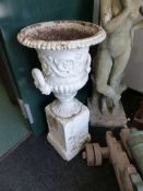 A LARGE VICTORIAN CAST IRON GARDEN URN ON ASSOCIATED PLINTH. H.OVERALL 103cms.