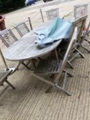 A TEAK EXTENDING PATIO TABLE AND EIGHT CHAIRS COMPLETE WITH PARASOL ONE CHAIR A/F