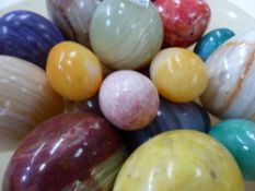 A COLLECTION OF HARDSTONE EGG FORM HAND COOLERS OF VARIOUS SIZES AND COLOURS.