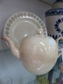 AN ENGLISH CREAMWARE GLOBULAR TEAPOT WITH INTERLACED HANDLE TOGETHER WITH A PIERCED RIM PLATE. (2).