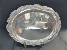 A CONTINENTAL SILVER COLOURED OVAL TRAY WITH EMBOSSED C-SCROLL DESIGN AND REPOUSSE FOLIATE