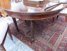 A VICTORIAN MAHOGANY WIND OUT EXTENDING DINING TABLE ON DETACHABLE REEDED LEGS.