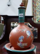 A NEAR PAIR OF VICTORIAN TERRA COTTA COVERED BOTTLE FORM VASES WITH UNDERTRAYS, EACH WITH POLYCHROME