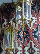 A PAIR OF BRASS VICTORIAN STYLE CYLINDER FORM HALL LANTERNS. H.87cms.