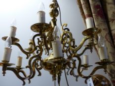 A PAIR OF BRASS DUTCH STYLE TWELVE LIGHT CHANDELIERS. H.78cms.