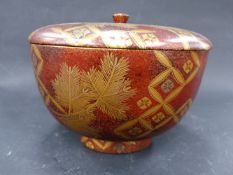 A JAPANESE LACQUER COVERED BOWL. EVERGREEN NEEDLES AND BLOSSOM ON A GOLD FLECKED BROWN GROUND,