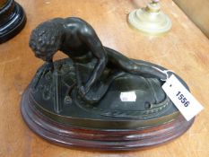A 19TH CENTURY BRONZE OF A WOUNDED WARRIOR ON CONFORMING OVAL HARDWOOD BASE. OVERALL HEIGHT 20CM.
