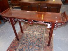 A CHINESE CARVED HARDWOOD ALTAR TABLE WITH PIERCED BRACKETS AND APRON. 135CM LONG.