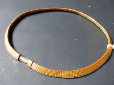 A gold coloured flexible necklace. Approximately 19grams