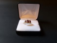 A 9ct gold ruby and diamond three stone cluster ring.