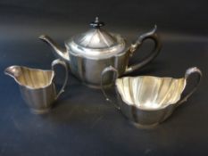 A silver three piece tea set with ebonized handle and finial to teapot, Sheffield 1919. weight all