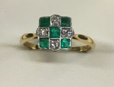 An 18ct diamond and emerald set chequerboard ring.