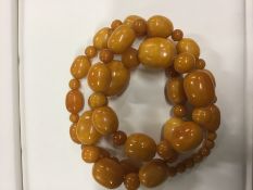 A graduated butterscotch colour amber necklace. 76cm long. Approximately 95grams