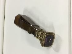 A gilt metal desk seal with polished faceted agate handle and amethyst type intaglio. Bryn. 7.5cm