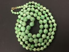 A graduated jade bead necklace, approximately 80cm long.