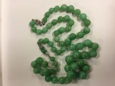 A graduated jade set necklace with white 9ct gold clasp and diamond set clasp (can be worn as a