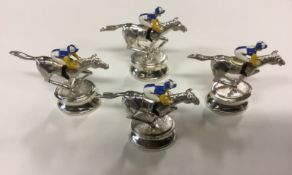 A set of four silver and enamel miniature race horses with jockeys on oval plinth bases. Maker