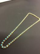 A late 19th/early 20th Century precious metal set graduated turquoise necklace with box clasp.