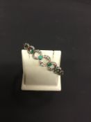 A Belle Epoche diamond and emerald set openwork bracelet set with old cut diamonds.