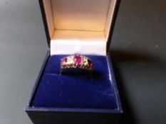 An 18ct gold three stone ruby and diamond set dress ring.