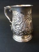 A George III silver baluster tankard with C-scrolled handle later repousse foliate decoration.