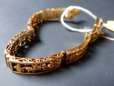 An 18k precious metal Peruvian bracelet decorated with figures and llamas in relief. 38grams