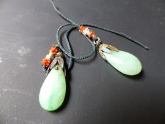 A pair of jade drop earrings with metal mounts, each drop approximately 2cm.