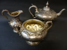 An early Victorian silver three piece tea set with repousse scrolled decoration. London 1838. Makers