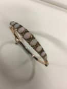 A circa 1920's opal set stiff bracelet with diamond points.