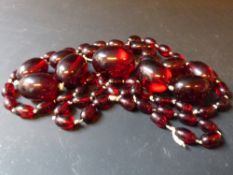 A graduated red amber necklace. 112cm long