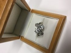 A ladies two stone diamond cross-over ring with diamond set leaf shoulder, each diamond