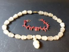 An alabaster acorn stylized necklace together with a coral bracelet