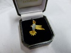 A 18K DIAMOND AND RUBY SET HUMMING BIRD BROOCH. APPROXIMATELY 3 GRAMS