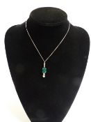 AN EMERALD AND DIAMOND PENDANT SUSPENDED FROM FOUR SMALL DIAMONDS WITH A FURTHER TWO GRADUATED