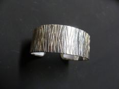 A GUILD OF HANDICRAFT SILVER BANGLE WITH BARK EFFECT FINISH. LONDON 2005. 2.2 OZS