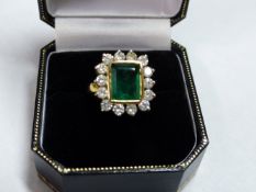 A DIAMOND AND BAGUETTE CUT EMERALD CLUSTER DRESS RING. APPROXIMATE SIZE OF EMERALD 1CM X 0.70MM