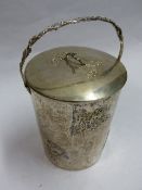 A CHINESE SILVER COLOURED BISCUIT JAR AND COVER WITH SWING HANDLE AND EMBOSSED PRUNUS DECORATIONS.