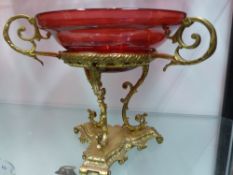 A CRANBERRY TAZZA ON ORMALU STAND