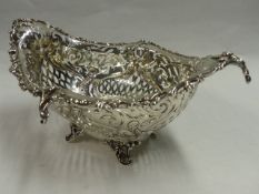 A PIERCED SILVER FRUIT BASKET WITH SCROLLED FEET, EMBOSSED FOLIATE DESIGNS. BIRMINGHAM 1908.