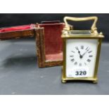 A CARRIAGE CLOCK IN LEATHER TRAVEL CASE