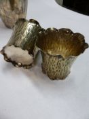 A SILVER PLATED HAMMERED VASE OF TAPERED FORM, 18CM HIGH AND A PAIR OF SMALLER VASES OF BARK