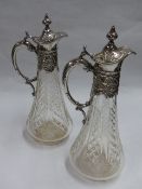 A PAIR OF GERMAN SILVER MOUNTED GLASS CLARET JUGS WITH REPOUSSE SCROLLED DECORATION. 800 STANDARD.