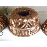 A VINTAGE COPPER JELLY MOULD, OPEN CENTRE WITHIN A LOBE-MOULDED GEOMETRIC BORDER, 9" DIAMETER AND