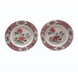 A PAIR OF 18TH CENTURY CHINESE PLATES, THE CENTRES PAINTED PREDOMINANTLY IN FAMILLE ROSE WITH FLORAL