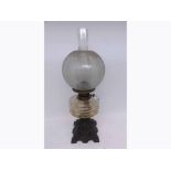 A VICTORIAN OIL LAMP WITH CLEAR GLASS CHIMNEY, FROSTED GLASS SHADE, CLEAR GLASS FONT, RAISED ON A