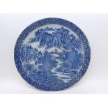 A CHINESE CIRCULAR PLATE PRINTED IN BLUE WITH A RIVER SCENE, 12 1/4" DIAMETER