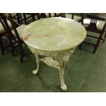 POLISHED ONYX TOP TABLE WITH THREE-FOOTED CAST IRON BASE, DECORATED WITH FLORAL SPRAYS AND