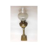 LARGE OIL LAMP FITTED WITH CLEAR GLASS CHIMNEY, FROSTED FRILLED GLASS SHADE, BRASS FONT, RAISED ON A