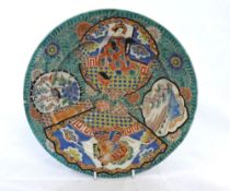 A CHINESE CIRCULAR PLATE, PAINTED WITH PANELS OF INTERIOR AND LANDSCAPE SCENES ON A PREDOMINANTLY