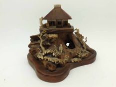 AN UNUSUAL CHINESE BONE/IVORY AND HARDWOOD MODEL OF A PAGODA ATOP A ROCKY INCLINE AND ALSO APPLIED